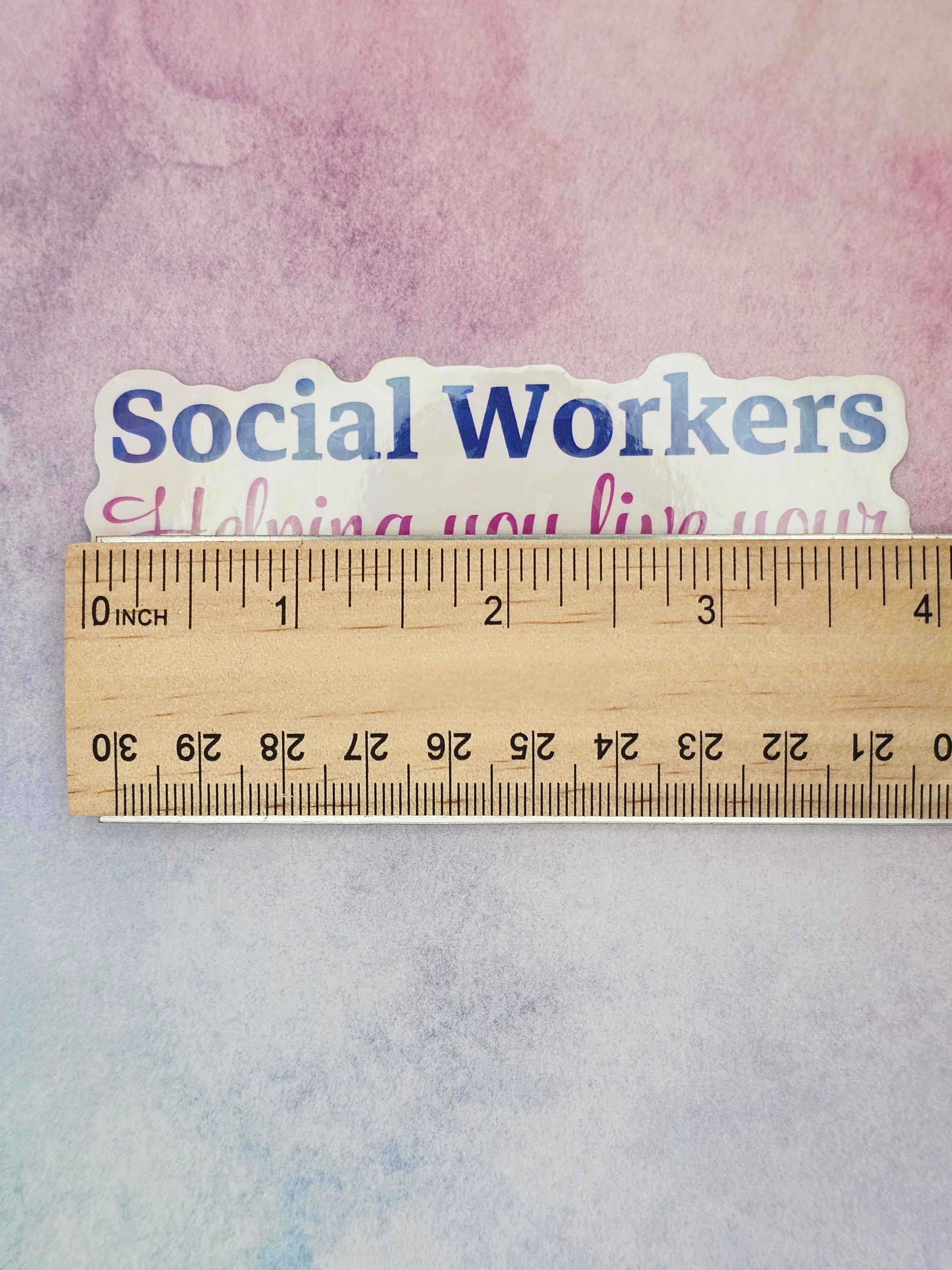 Sticker with 'Social Workers Helping You Live Your' text on a watercolor background with a ruler for scale.